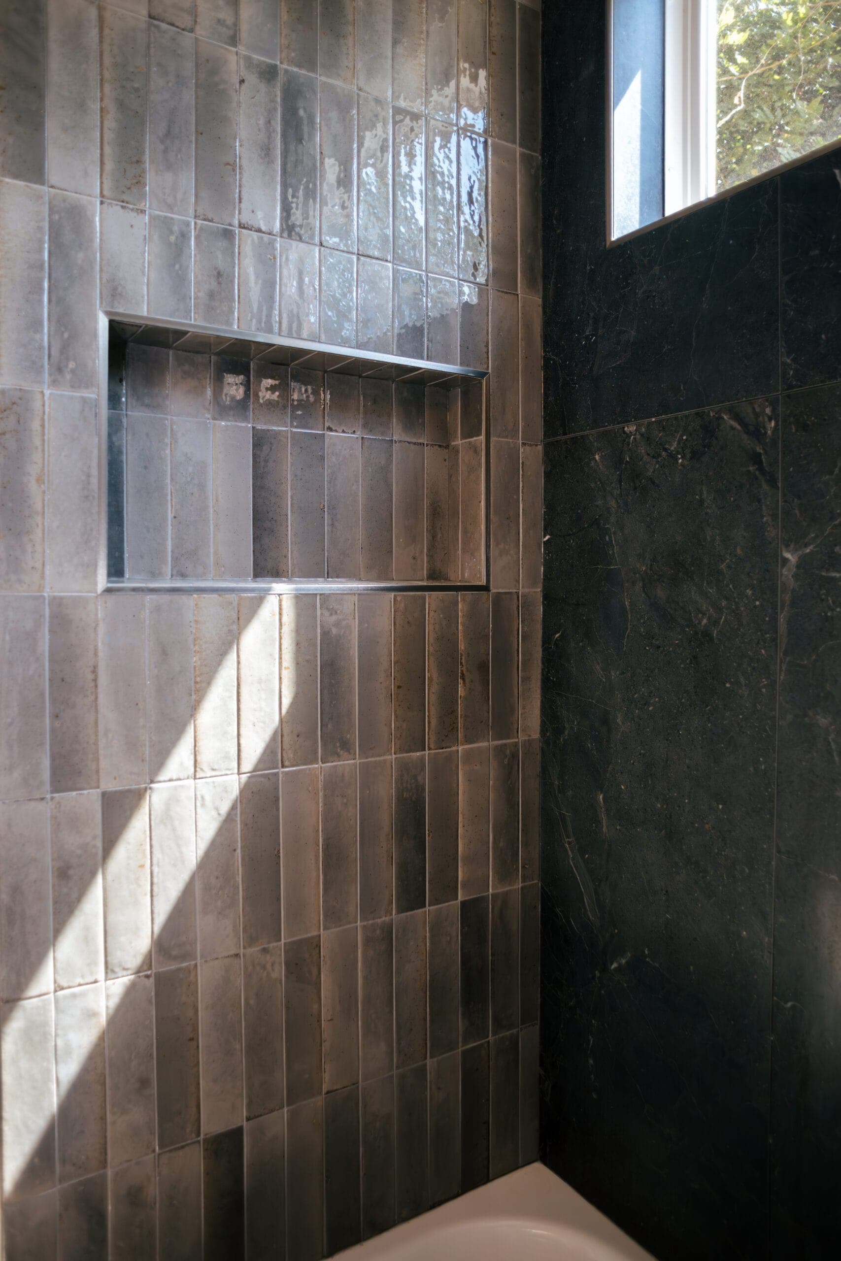 Recessed shower niche in a dark and tan tile surround — bathroom remodeling by Southlake Luxury Kitchens, serving Southlake, TX