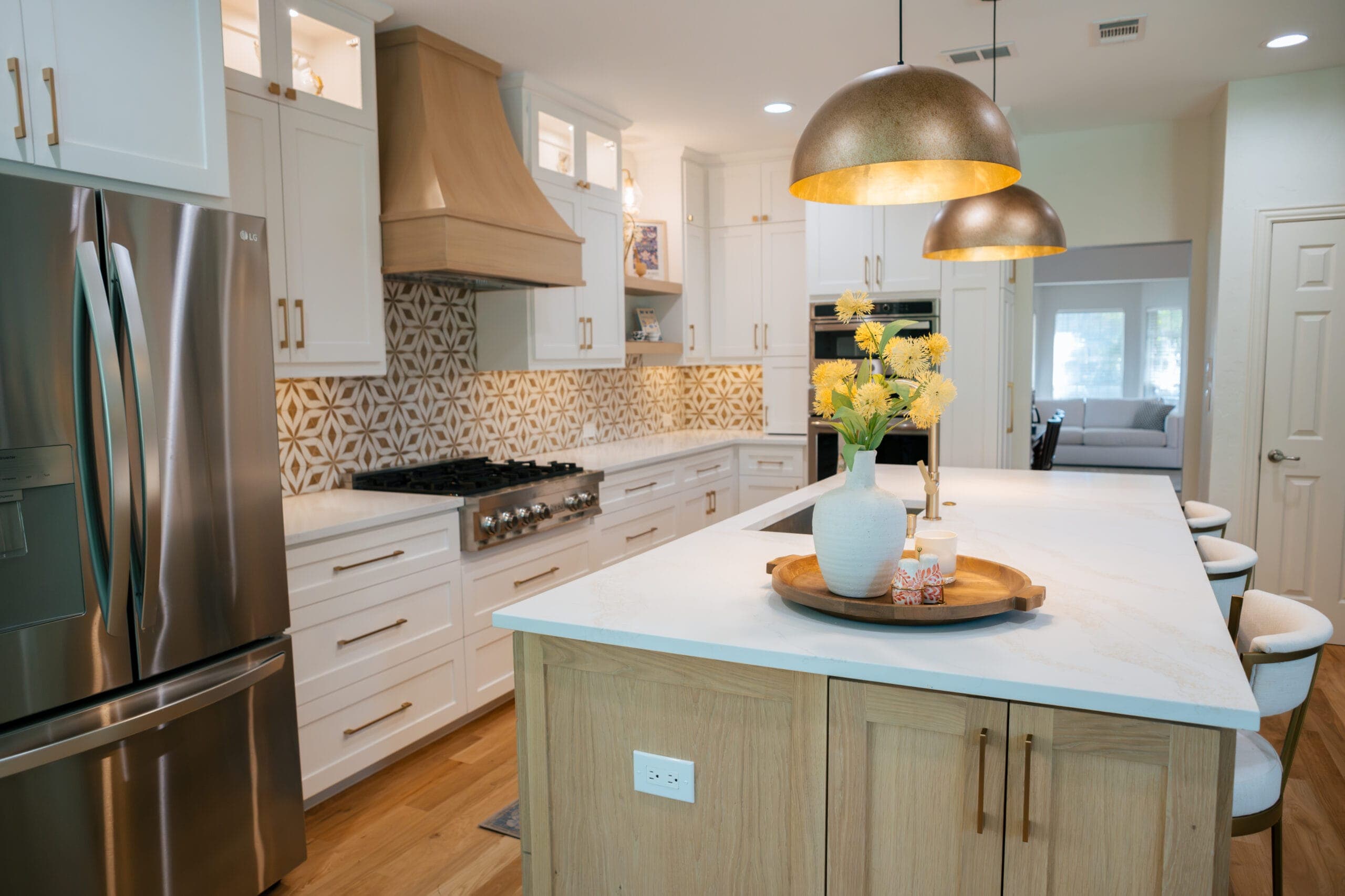 Remodeled kitchen seen from the dining room, with a white oak island and gold geometric tile backsplash