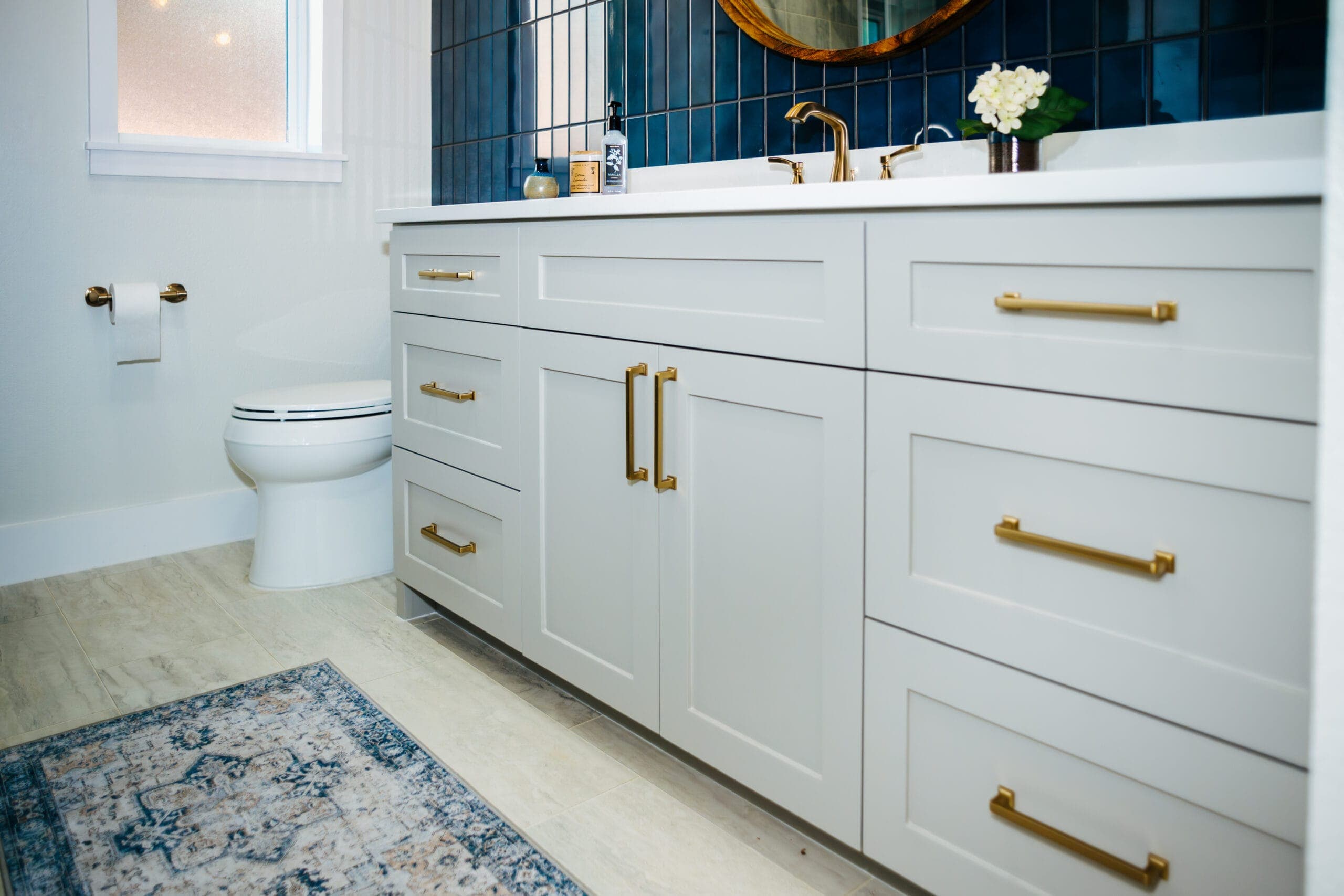 White shaker double vanity with brass pulls and a quartz counter