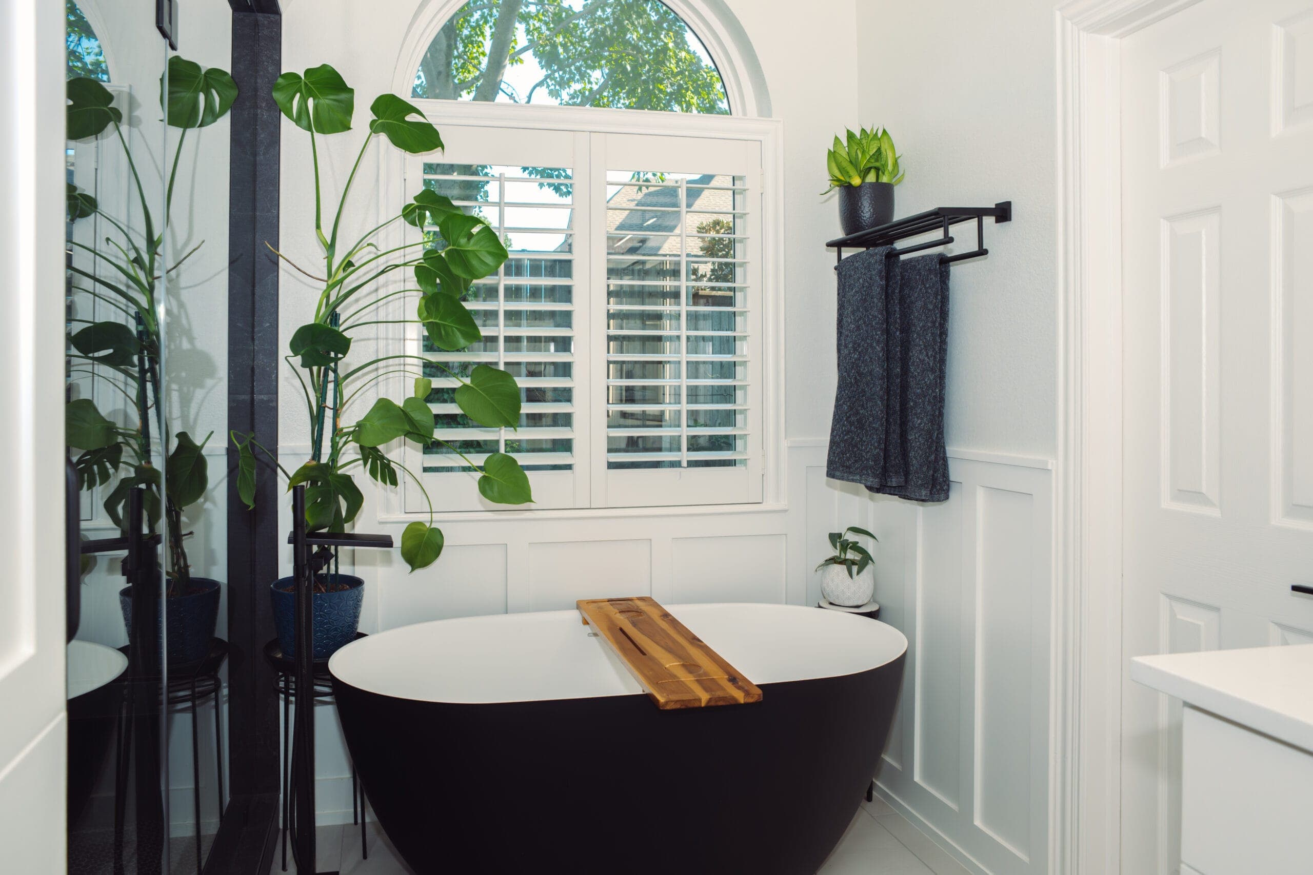 Arched window and white vanity in a remodeled primary bathroom