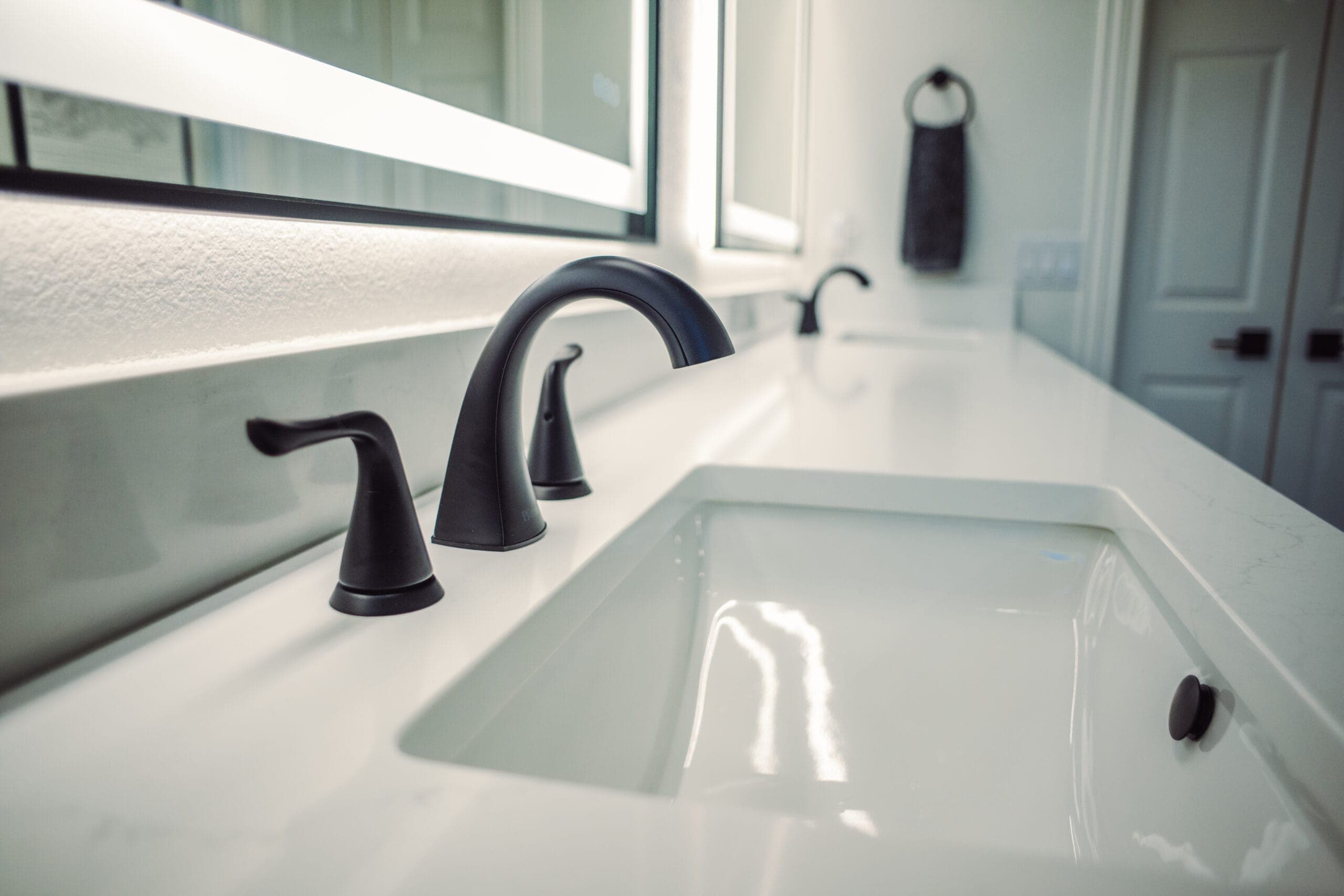 White quartz vanity counter with an undermount sink and matte black faucet