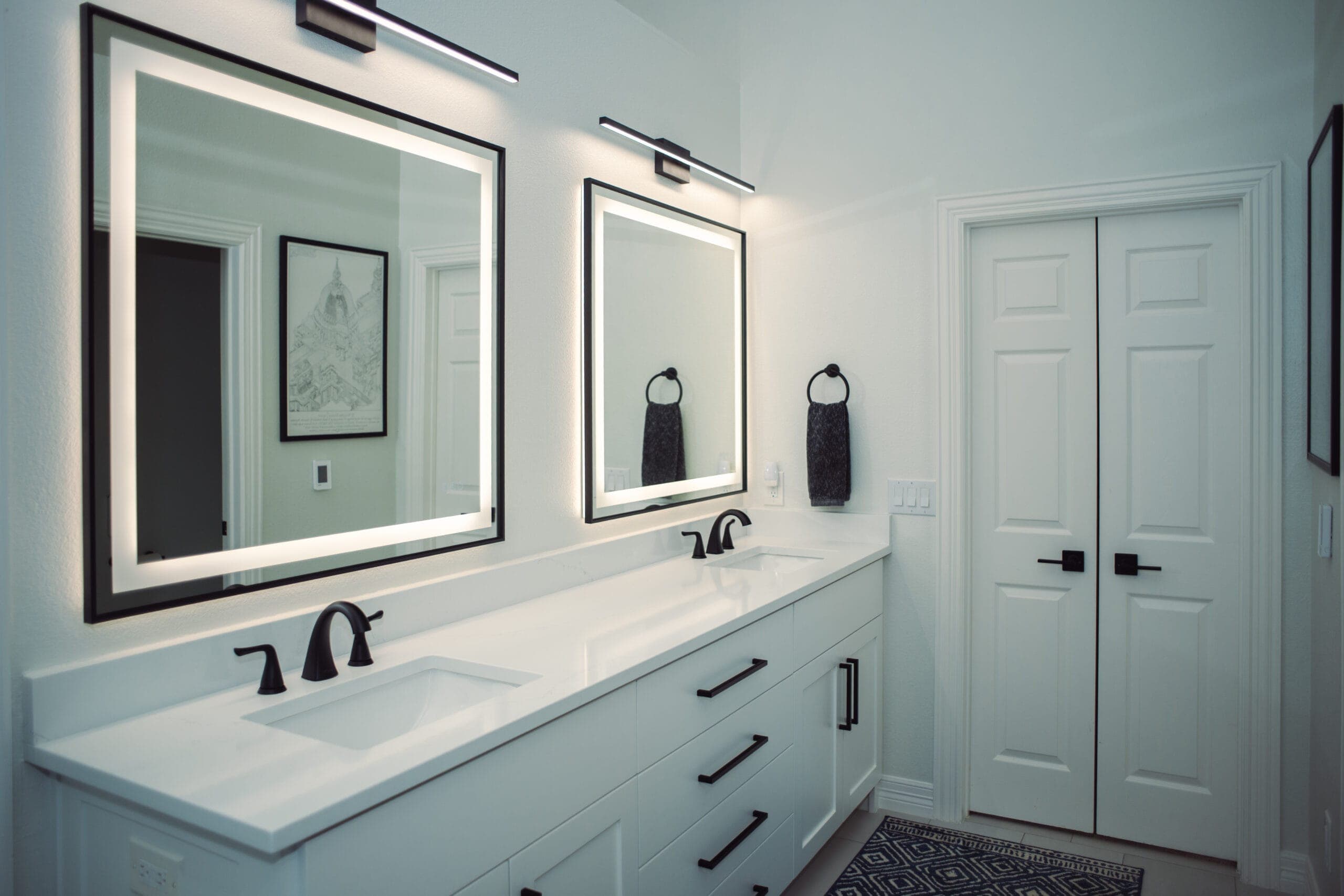 Dual sink vanity with black-framed LED-lit mirrors — bathroom remodeling by Southlake Luxury Kitchens, serving Southlake, TX