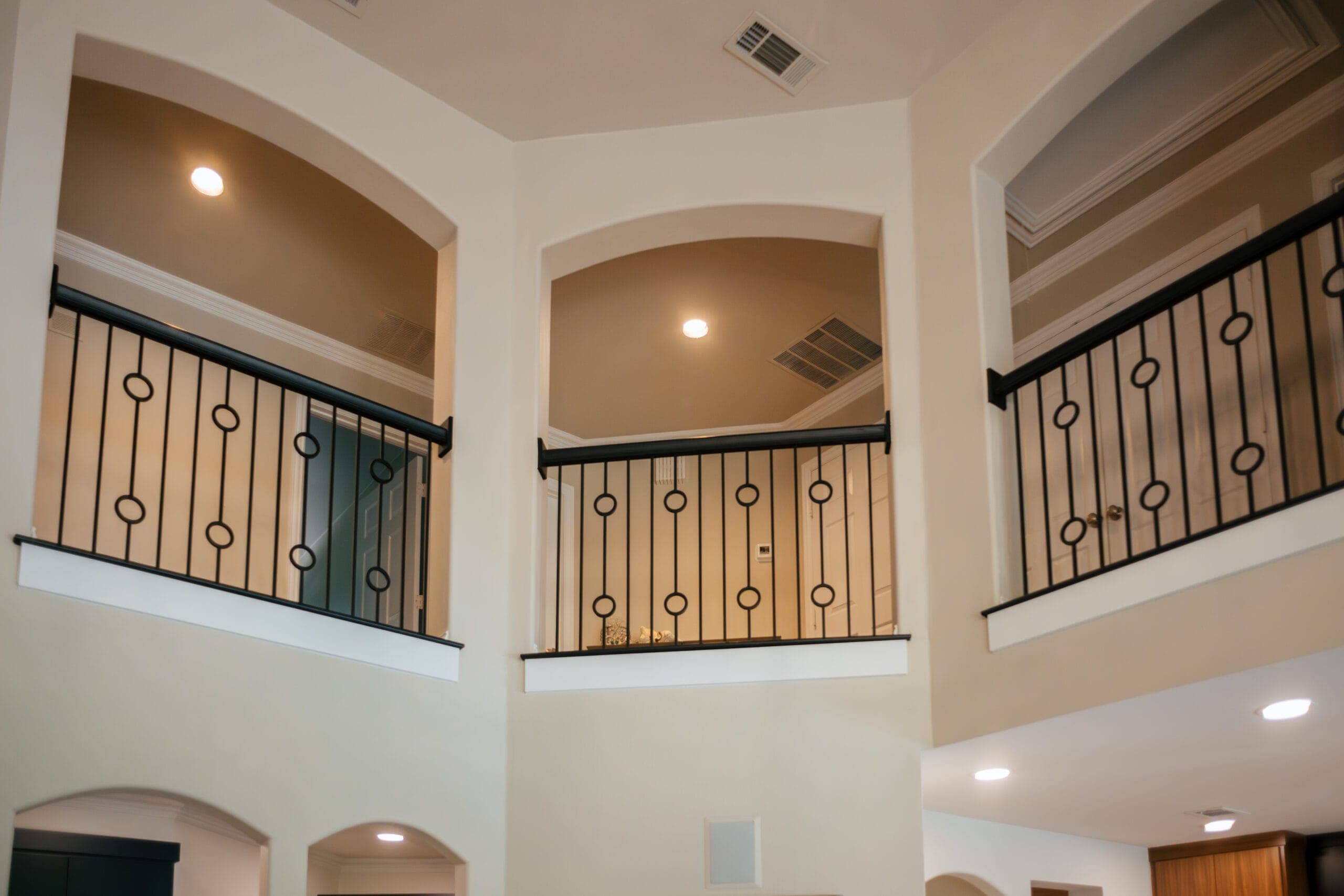 Two-story landing with iron balusters and arched openings — home remodeling by Southlake Luxury Kitchens, serving Southlake, TX