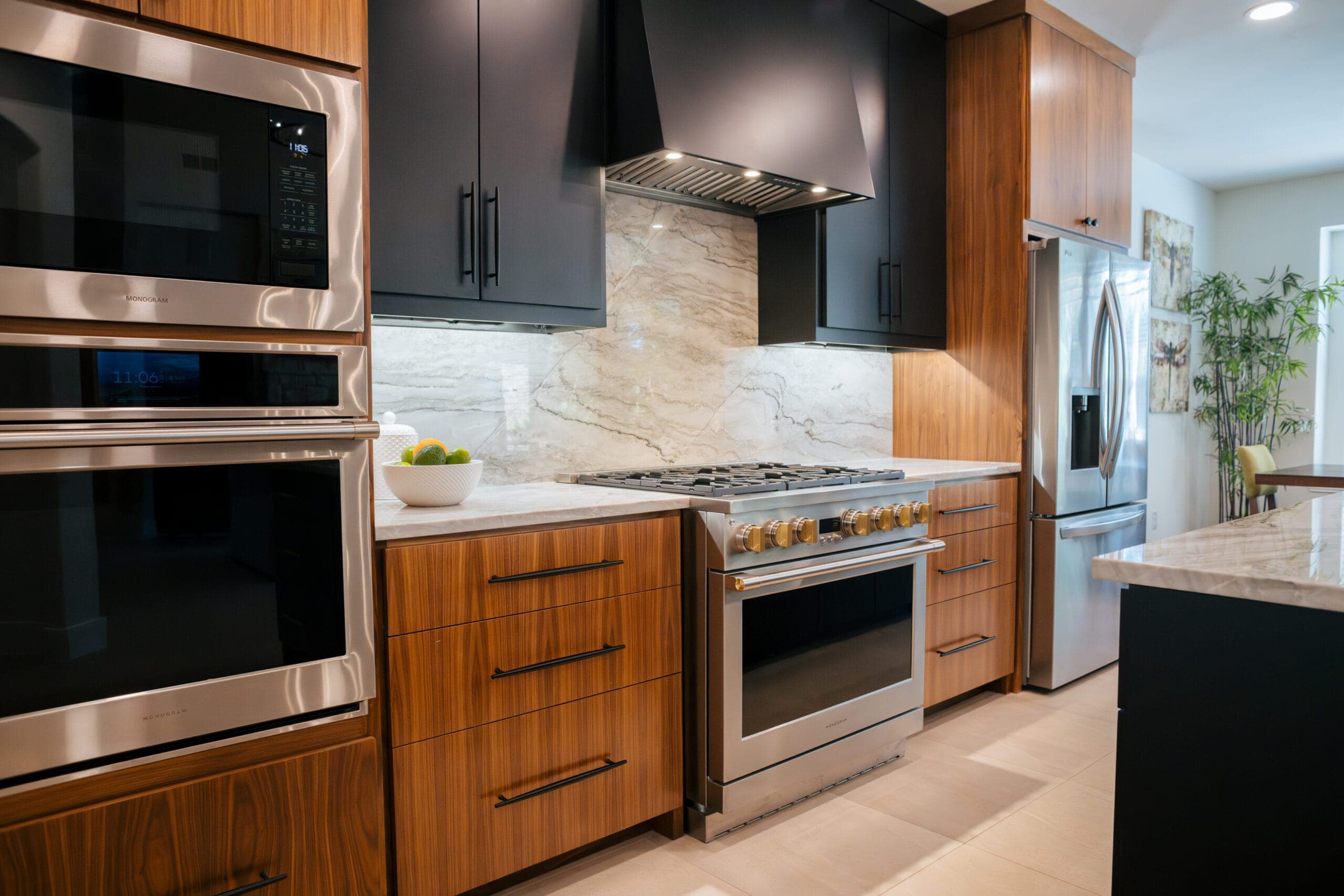 Built-in wall ovens and microwave in a walnut cabinet tower beside the range wall