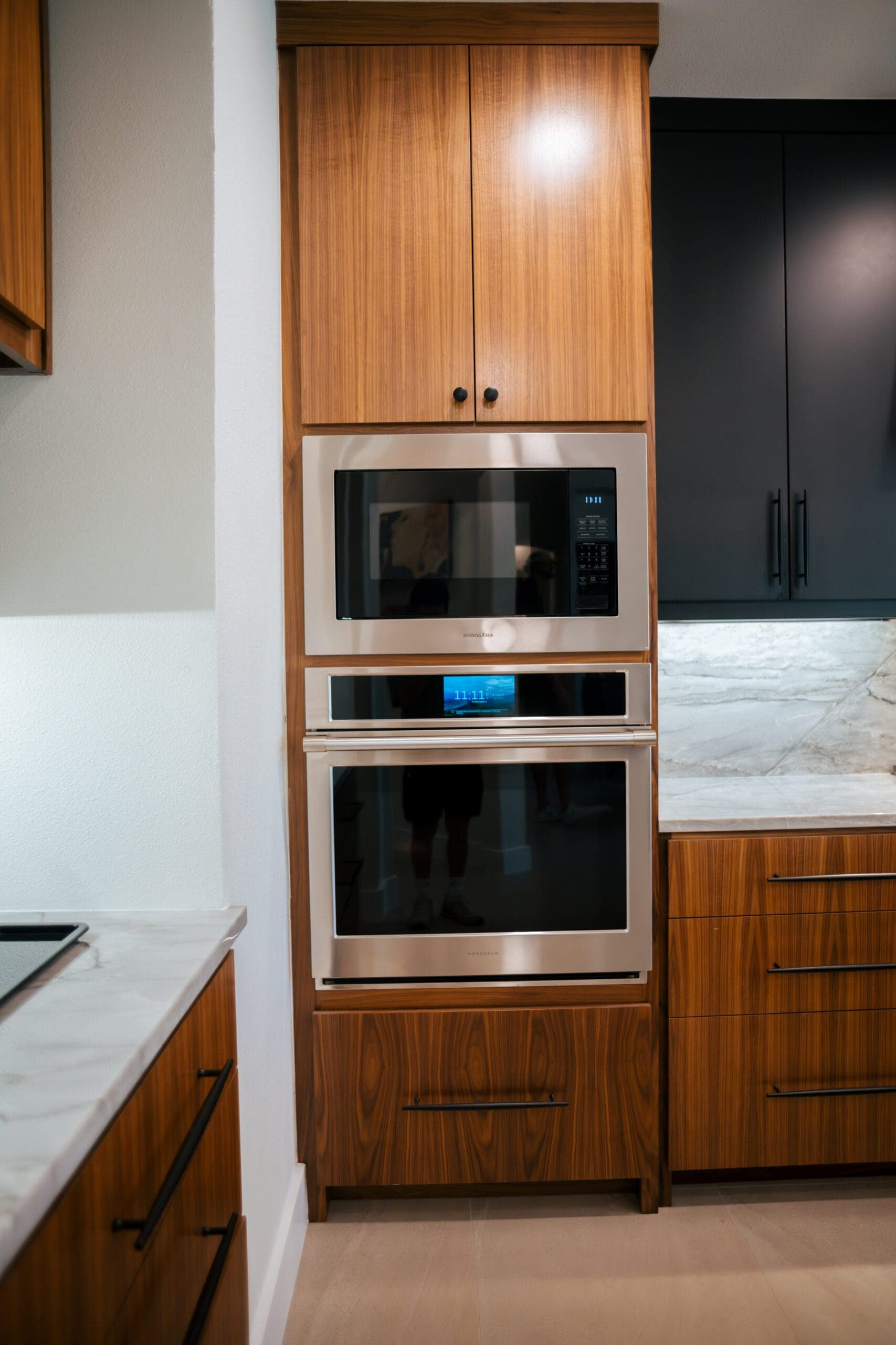 Walnut appliance tower housing a built-in microwave and oven