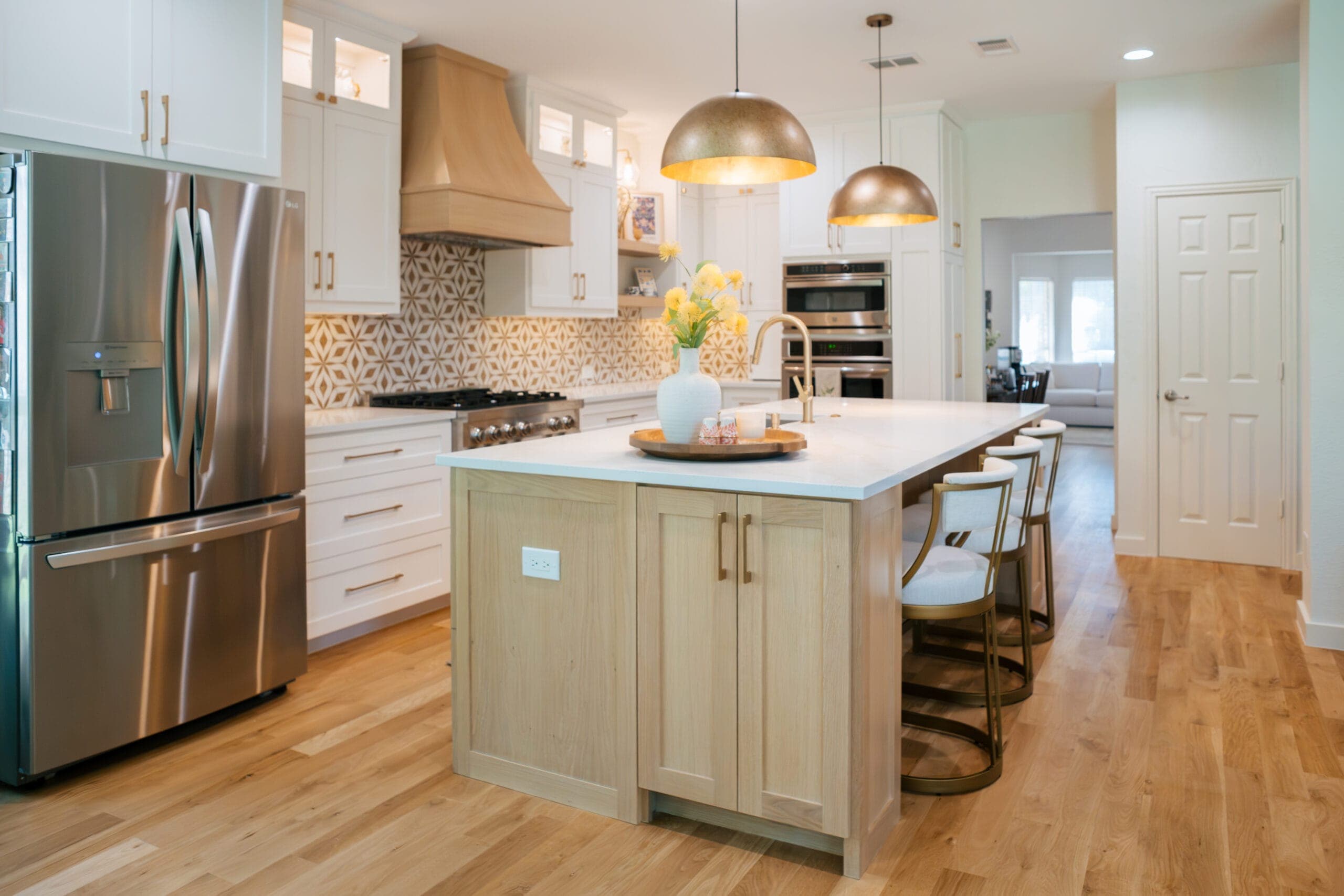 White oak island and hardwood floors with a counter-depth stainless refrigerator