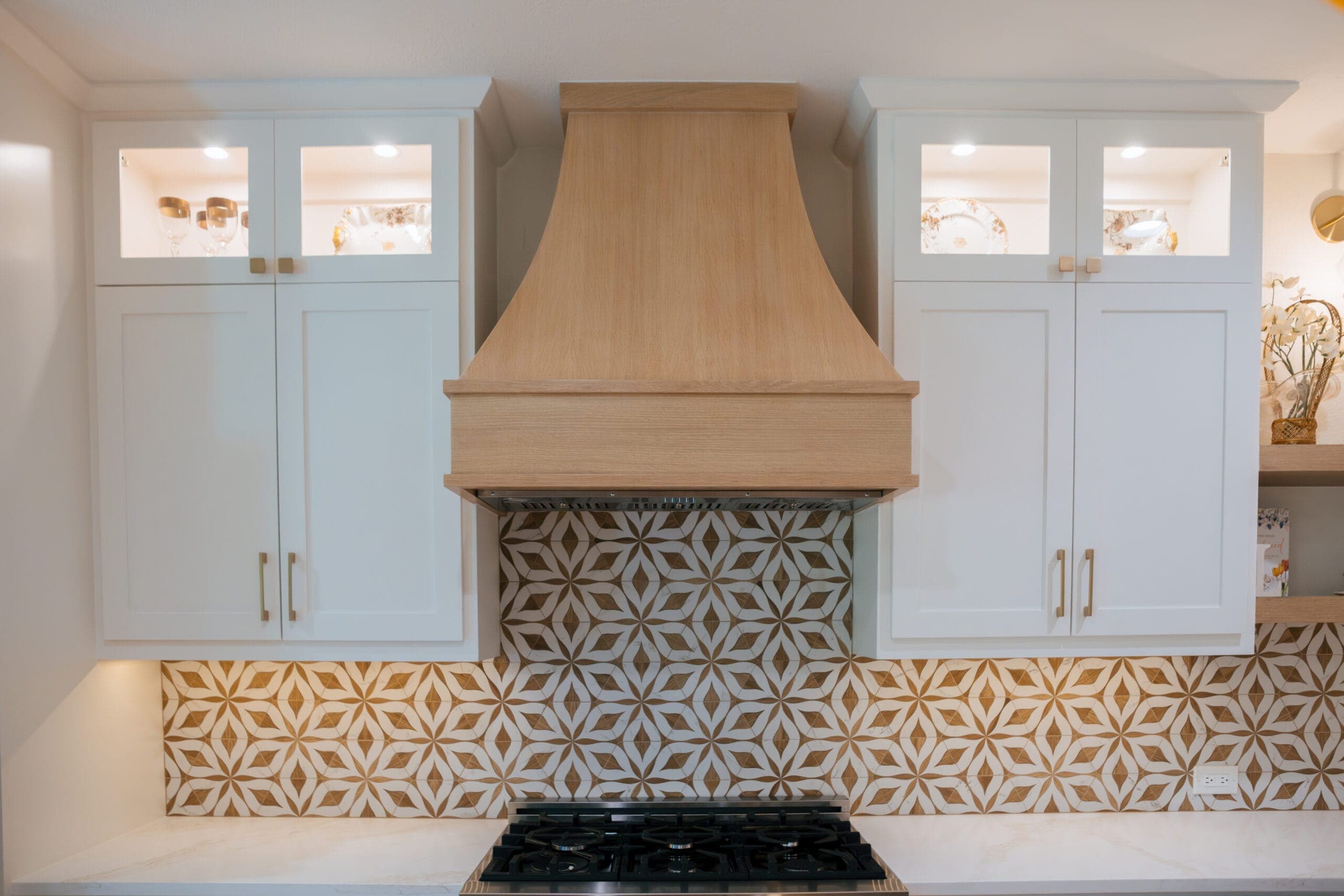 Custom white oak range hood centered between glass-front upper cabinets — Southlake Luxury Kitchens kitchen remodeling, serving Southlake, TX