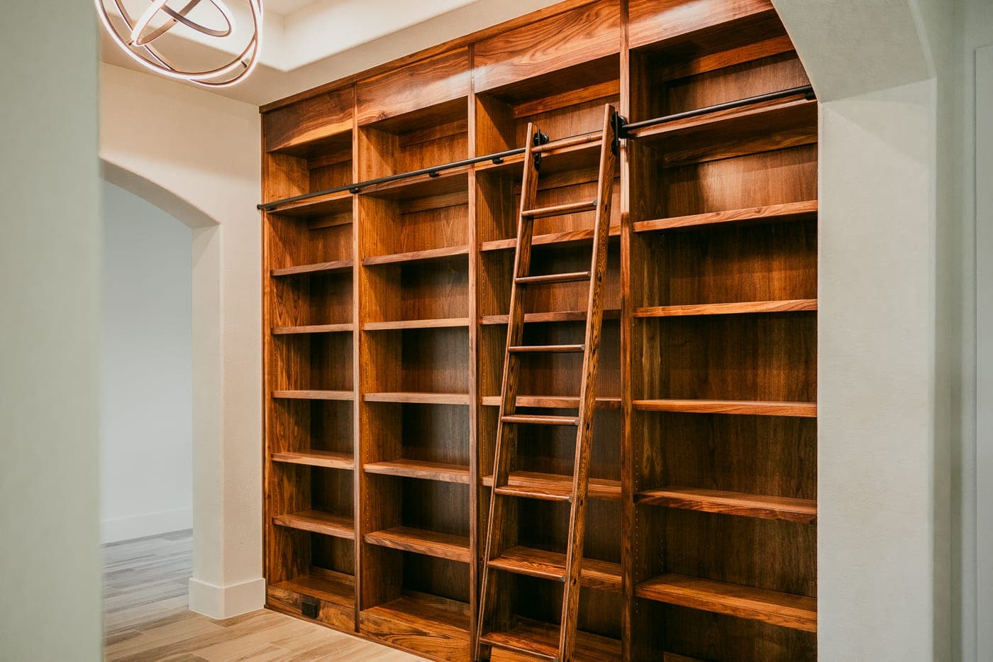 Floor-to-ceiling built-in wood bookcases with a rolling library ladder