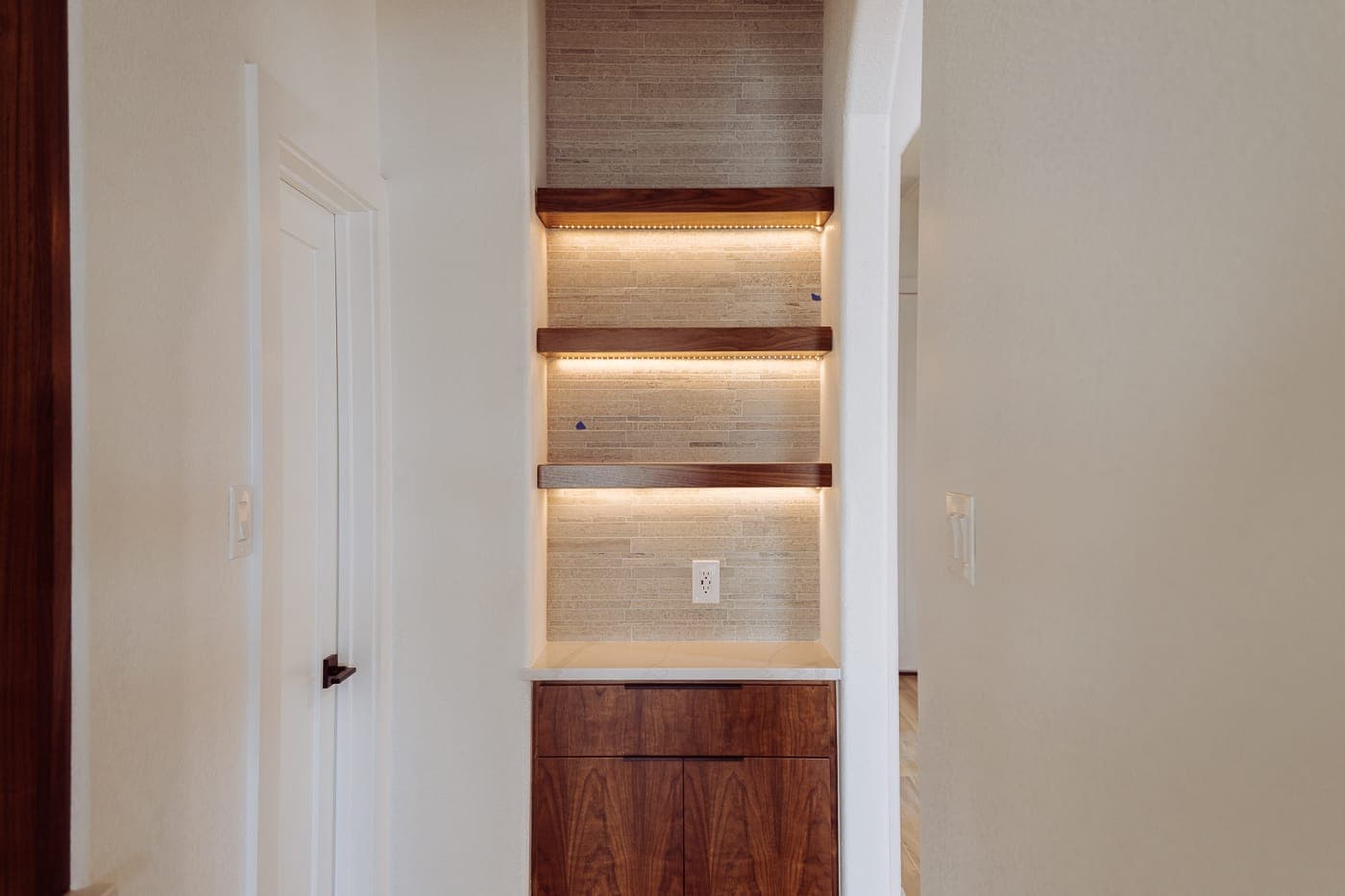 Recessed display niche with integrated lighting in a renovated hallway