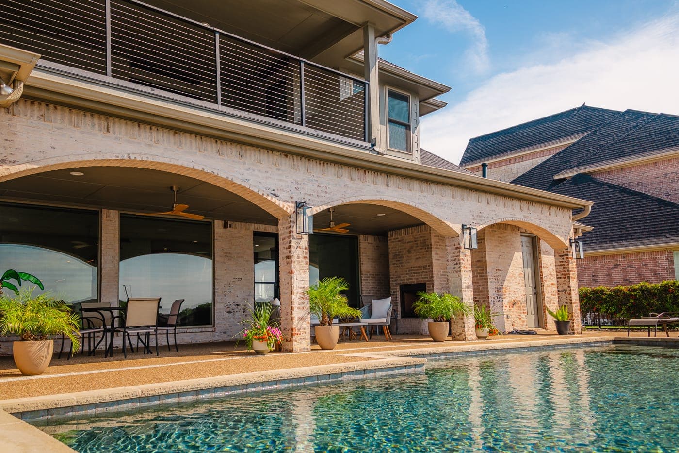 Pool and covered patio framed by brick arches