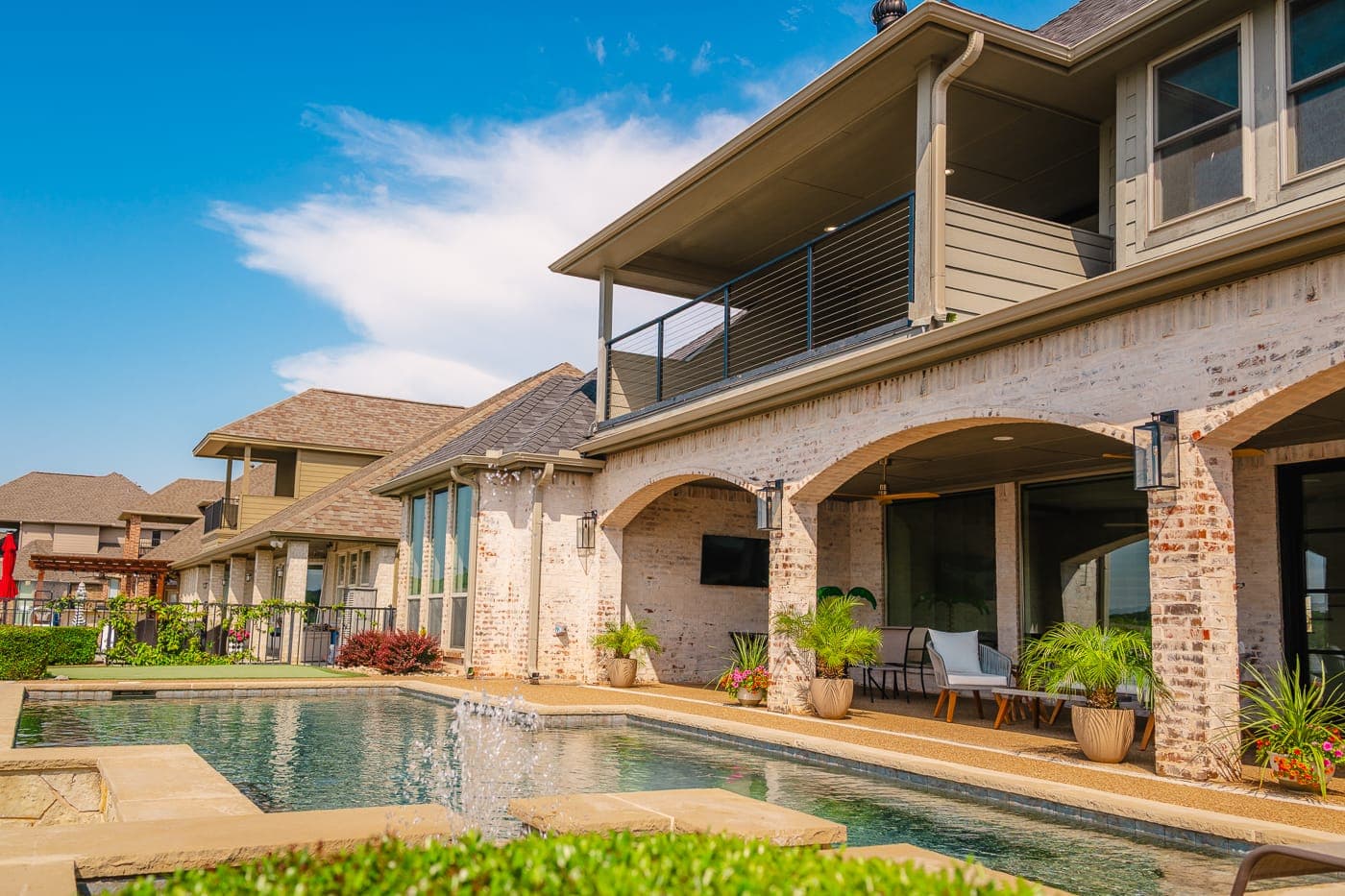 Pool deck and brick arcade along the back of the house