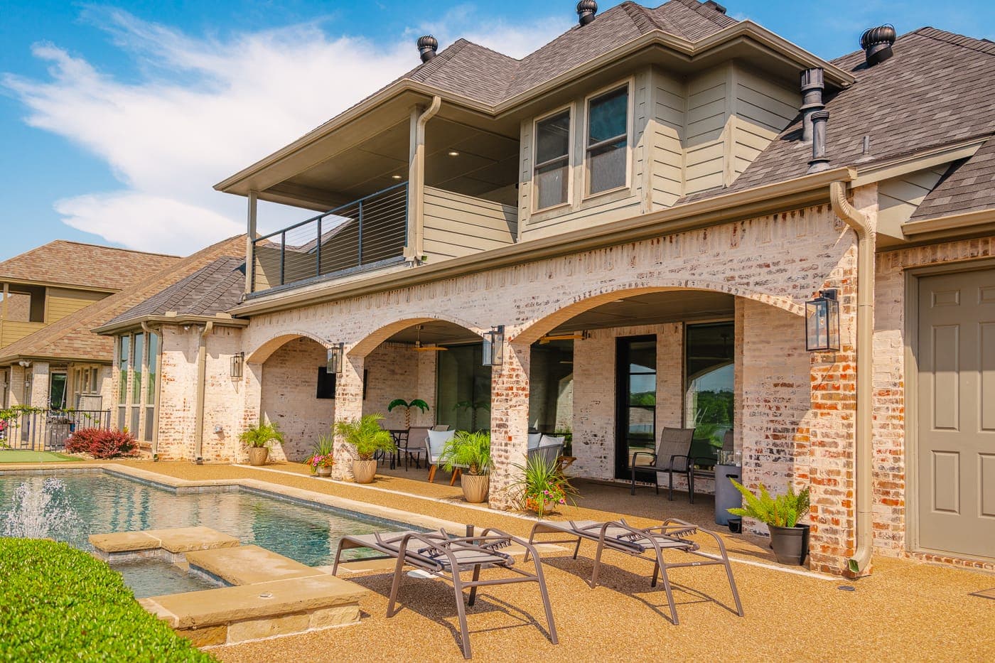 Rear elevation with pool, patio seating and a fire pit